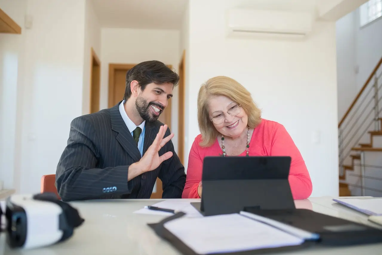 Happy Lady sitting with a younger well dressed gentleman together looking at tablet