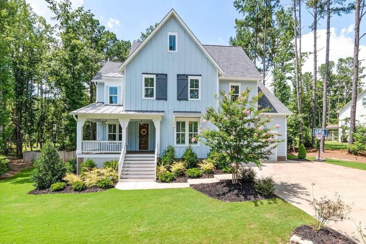 Beautiful detached blue house with a green lawn in front