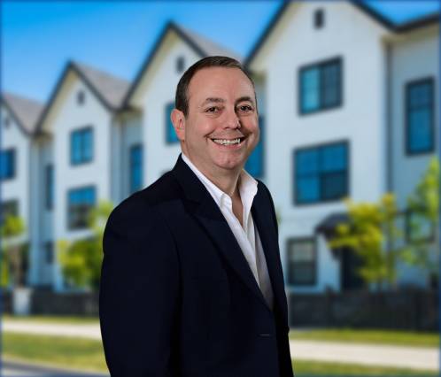 picture of chris clarke smiling with a house on the background