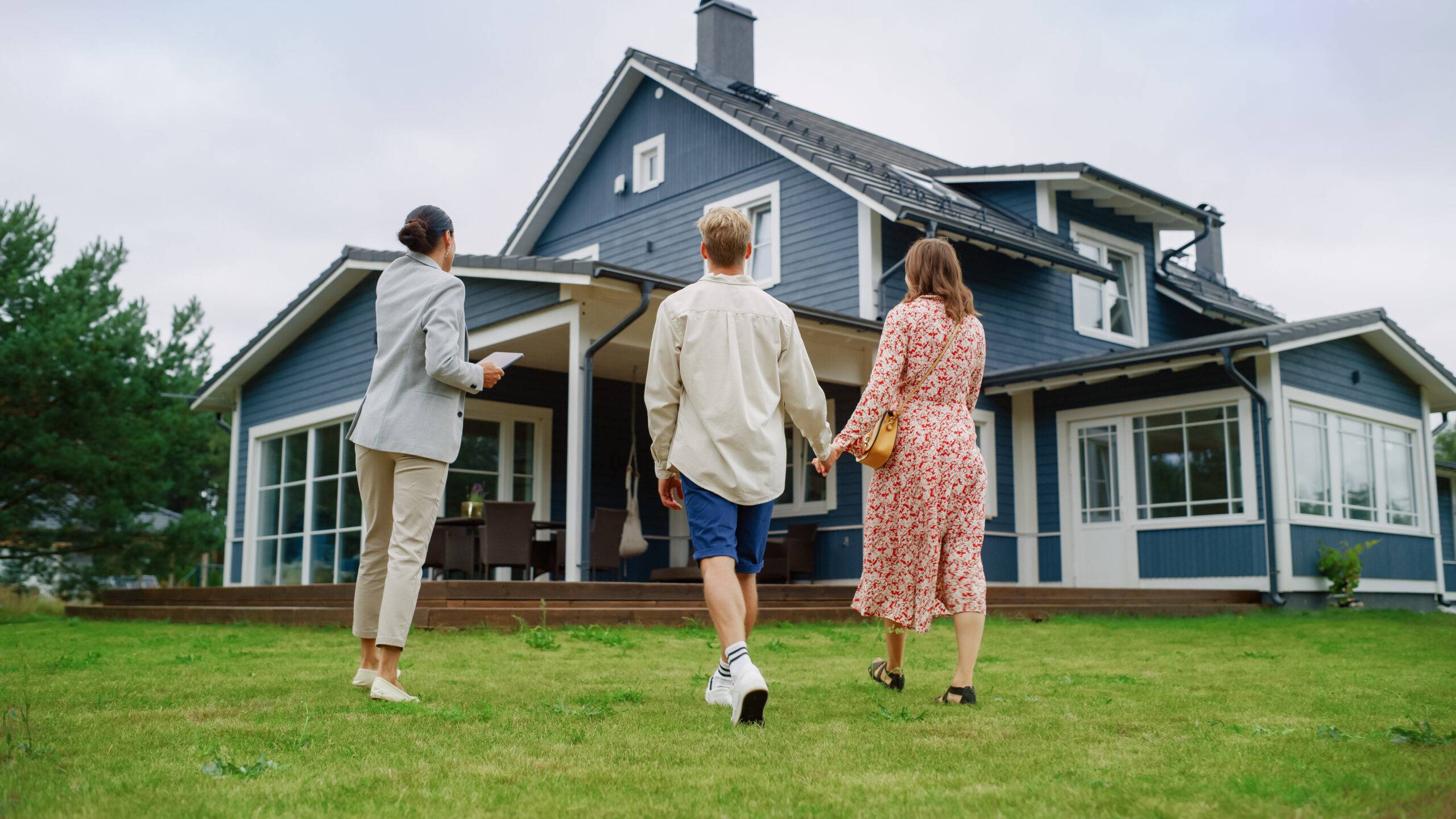 A female property manager showing a property to prospective tenants.