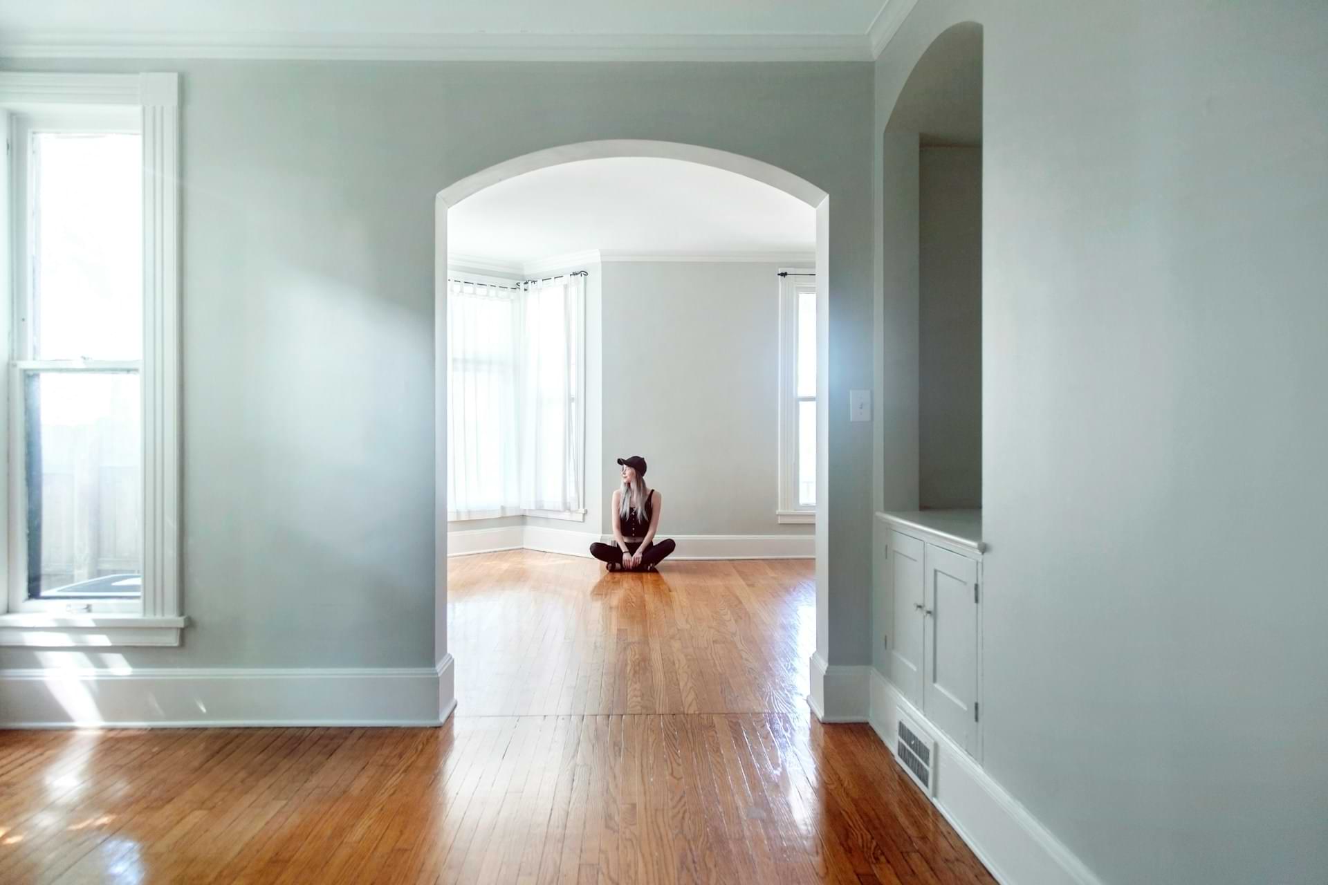 girl sitting on the floor in an empty apartment